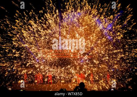 Pulvérisation artistes du fer en fusion pour simuler l'affichage d'artifice lors d'un spectacle traditionnel chinois lors d'une foire dans la ville, le centre de la Chine Yongcheng Henan du pro Banque D'Images