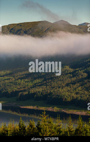 Loch Garry dans les Highlands écossais comme la lumière du matin et de la brume de graver sur un matin d'été Banque D'Images