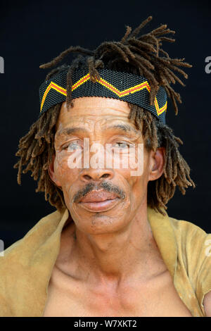 Portrait de Naro San Bushman portant des vêtements traditionnels et bandeau, Kalahari, région de Ghanzi, Botswana, l'Afrique. Octobre 2014. Banque D'Images