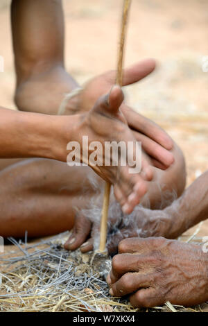 Naro San Bushman faisant feu en frottant stick, Kalahari, région de Ghanzi, Botswana, l'Afrique. Saison sèche, octobre 2014. Banque D'Images