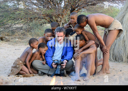 Eric Baccega photographe montrant des images de Naro San Bushmen famille avec enfants portant des vêtements traditionnels à base de cuir duiker. Kalahari, région de Ghanzi, Botswana, l'Afrique. Saison sèche, octobre 2014. Banque D'Images