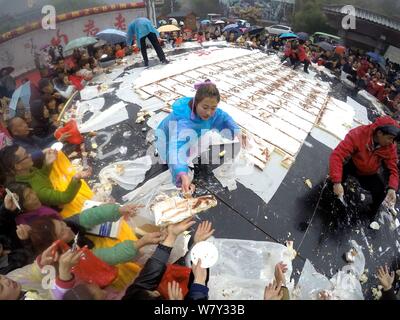 Les gens partagent un gâteau géant pour célébrer le 2,588ème anniversaire du fondateur du Taoïsme Laozi (Lao Tseu) sur la montagne Laojun dans Luoyang city, le centre de la Chine" Banque D'Images