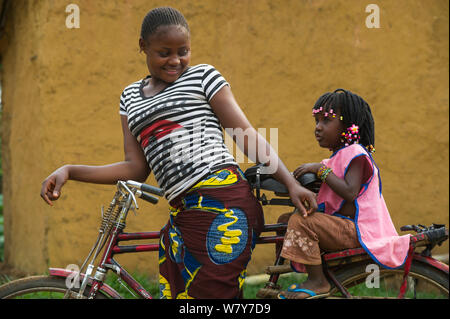 Femme et fille sur le vélo, Mbomo, Village du Parc National Odzala-Kokoua, République du Congo (Congo-Brazzaville), l'Afrique, mai 2013. Banque D'Images