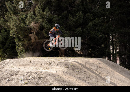 Mtb biker jumping on a dusty jump Banque D'Images