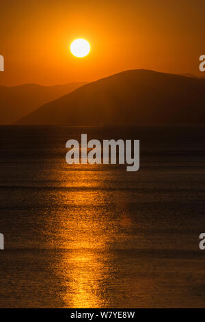 Coucher du Soleil reflété sur la surface de la mer par une journée calme, Île d'Eubée, Grèce. Juillet 2014. Banque D'Images