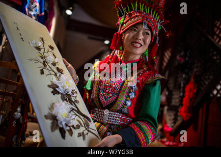 (190807) -- d'HOTEL PARTICULIER, 7 août 2019 (Xinhua) -- Zhang Hua affiche sa mosaïque de plumes aux touristes dans le comté d'Hotel Particulier, préfecture autonome Hani-Yi de Honghe, sud-ouest de la province chinoise du Yunnan, 7 août 2019. Né à Longpeng Canton d'Hotel Particulier, Comté de Yi Zhang Hua, groupe ethnique, s'intéresse à la broderie Yi à partir d'un très jeune âge et a commencé à apprendre ce patchwork plume depuis 2009. En 2016, Zhang Hua fonde un studio pour aider les femmes apprennent la broderie et art plumes pour libre. Puis avec l'appui du gouvernement local, elle a organisé une coopérative spécialisée art plume à b Banque D'Images