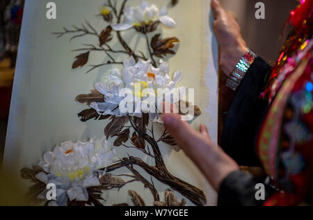 (190807) -- d'HOTEL PARTICULIER, 7 août 2019 (Xinhua) -- Zhang Hua affiche sa mosaïque de plumes dans le comté d'Hotel Particulier, préfecture autonome Hani-Yi de Honghe, sud-ouest de la province chinoise du Yunnan, 7 août 2019. Né à Longpeng Canton d'Hotel Particulier, Comté de Yi Zhang Hua, groupe ethnique, s'intéresse à la broderie Yi à partir d'un très jeune âge et a commencé à apprendre ce patchwork plume depuis 2009. En 2016, Zhang Hua fonde un studio pour aider les femmes apprennent la broderie et art plumes pour libre. Puis avec l'appui du gouvernement local, elle a organisé une coopérative spécialisée art plume à stimuler des sections locales Banque D'Images