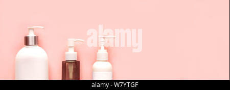 Distributeurs de blanc sur fond rose, bannière, copiez l'espace. La pompe en plastique blanc pour bouteilles de shampoing et de savon ou crème, soin de concept. Banque D'Images