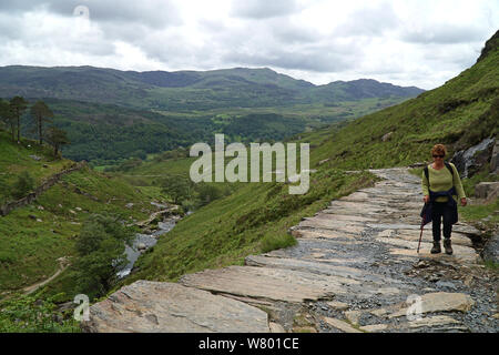 Une femme marche Watkins chemin jusqu'au sommet du Mont Snowdon dans le parc national de Snowdonia dans le Nord du Pays de Galles, Royaume-Uni Banque D'Images