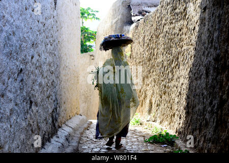 Femme musulmane marcher dans les rues étroites, Harar, une importante ville sainte dans la foi islamique, UNESCO World Heritage Site. L'Éthiopie, Novembre 2014 Banque D'Images