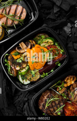 Close up of grilleled légumes, viandes et poissons dans les boîtes noires Banque D'Images