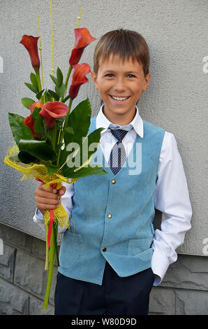 Garçon avec des fleurs 1 septembre va à l'école Banque D'Images