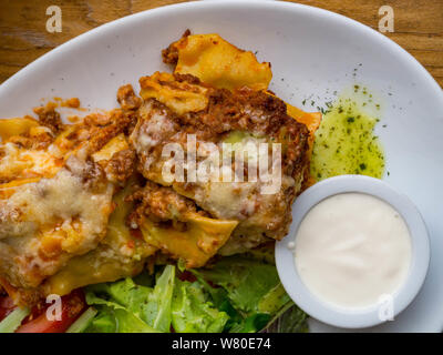 Lasagne classique - Restauration rapide, tomate et fromage Lasagne au boeuf entre les couches de feuilles de pâtes italiennes traditionnelles servi sur une plaque blanche sur un reste Banque D'Images