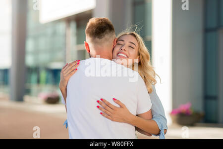 Rencontre couple après un long moment, serrant près de l'aéroport Banque D'Images