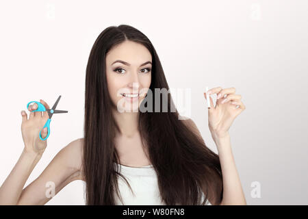 Portrait Of Beautiful Smiling Woman Holding Cigarette et des ciseaux dans les mains. Arrêter de fumer la cigarette Concept. La haute résolution Banque D'Images