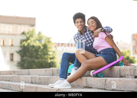 Couple of teenagers sitting on stairs posant à l'appareil photo Banque D'Images