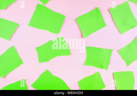 Résumé fond avec des morceaux de papier déchiré vert sur fond rose. séries photo Banque D'Images