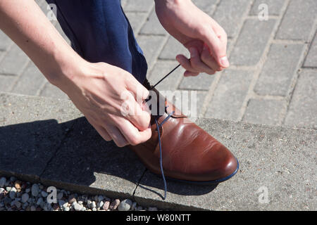 Lacets pour chaussures homme attachant sur la rue Banque D'Images