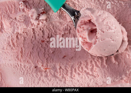 Vue de dessus de la crème glacée saveur fraise avec écope dans la boîte. L'accent sur la cuiller à glace. Banque D'Images
