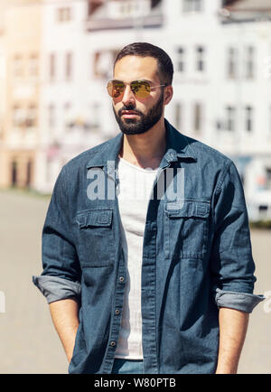 Succès permanent antrepreneur confiant devant un bulding en jeans shirt Banque D'Images