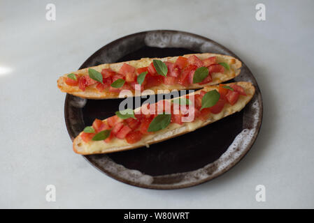 Bruschetta de fromage fondu de tomates hachées huile d'olive poivre noir lumière naturelle après-midi. Photo prise dans la ville de Rio de Janeiro, Brésil, 2019. Banque D'Images