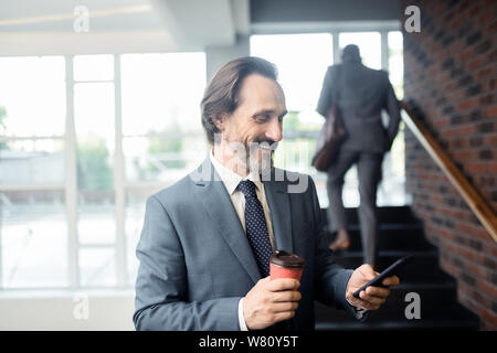 Homme aux cheveux gris se sentir satisfait après réception d'un e-mail Banque D'Images