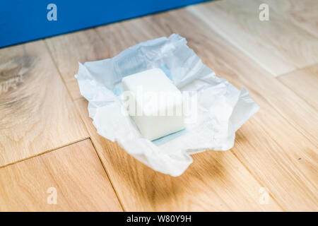 Un morceau de saindoux dans le papier déballé sur des planches symbolique d'une mauvaise alimentation, l'accumulation de graisse, de mauvaises habitudes alimentaires - et bien sûr un type ou de l'alimentation. Banque D'Images