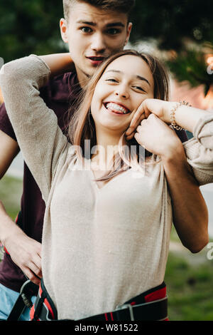 Close up portrait of young couple having fun in être heureux après avoir glisser la corde de l'adrénaline tandis que l'homme embrassant son amie alors qu'elle est l Banque D'Images