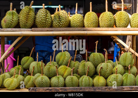 Pile de fruits Durian sur étagère en bois de bambou en face de magasin à la maison de la rue du marché en plein air dans la vieille ville de Chanthaburi, Thailande. Banque D'Images
