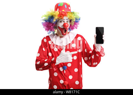 Happy Clown holding a mobile phone et en montrant qu'il isolé sur fond blanc Banque D'Images