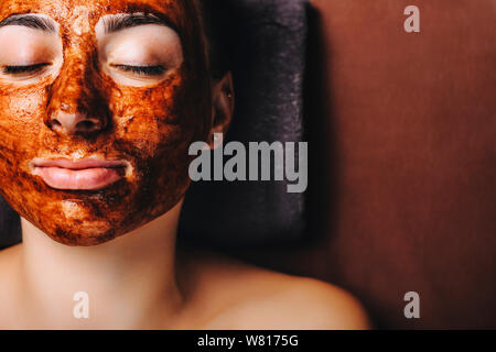 Vue supérieure d'une femme européenne incroyable alors que masque chocolat avoir appuyée sur un lit spa avec les yeux fermés dans un spa de bien-être resort pendant votre voyage en Banque D'Images