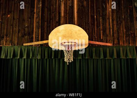 Panier de basket-ball marron et rouge près des rideaux verts Banque D'Images