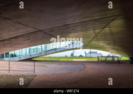 Rez-de-chaussée extérieur de Rolex Learning Center (EPFL) avec fasciner ondulant en béton plancher perforé et le toit avec façade en verre. Banque D'Images