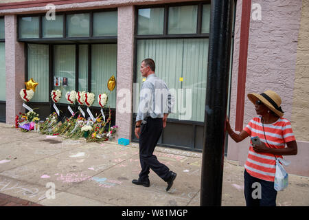 Un homme passe devant un mémorial à l'avant d'un bâtiment sur la 5e rue à l'emplacement de la prise de masse qui a laissé 9 morts et 27 blessés, mercredi, le 7 août 2019 à Dayton, Ohio. Trump a visité un hôpital proche, mais n'a pas visiter le site de la fusillade avant de s'envoler à El Paso, Texas, qui a également été le site d'une prise de masse. Banque D'Images