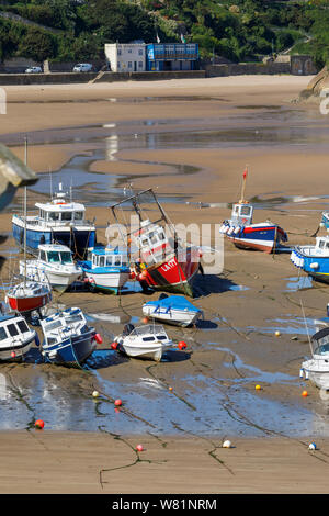 Les bateaux de pêche s'échouer à marée basse dans le port de Tenby, une ville balnéaire fortifiée dans la région de Pembrokeshire, Pays de Galles du sud sur la côte ouest de la baie de Carmarthen Banque D'Images