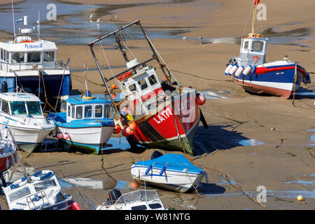 Les bateaux de pêche s'échouer à marée basse dans le port de Tenby, une ville balnéaire fortifiée dans la région de Pembrokeshire, Pays de Galles du sud sur la côte ouest de la baie de Carmarthen Banque D'Images