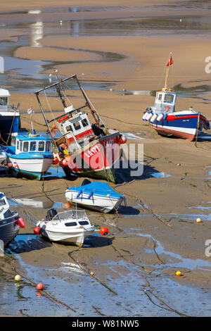 Les bateaux de pêche s'échouer à marée basse dans le port de Tenby, une ville balnéaire fortifiée dans la région de Pembrokeshire, Pays de Galles du sud sur la côte ouest de la baie de Carmarthen Banque D'Images