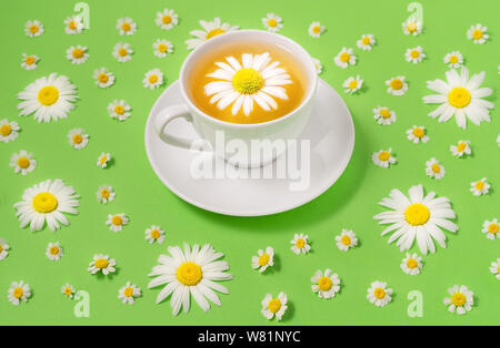 Tasse de thé de camomille fleurs avec des fleurs aux tons de vert sur la surface. Soins de santé et des aliments sains. Close-up. Banque D'Images