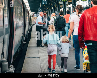 Paris, France - Oct 13, 2018 : vue arrière de mère seule avec deux filles de marcher sur la plate-forme du train rapide jusqu'à la gare TGV à proximité de la gare de Paris gare de l'Est chef d'orchestre et les clients contexte Banque D'Images