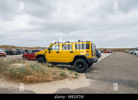 Overveen, Pays-Bas - Aug 16, 2019 - vue latérale du grand SUV de luxe Hummer jaune garée dans le parking couvert de sable Dutch payé Banque D'Images