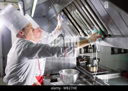 Jour sanitaire dans le restaurant. Lavez vos répétitions de travail. Laver cuisine four, cuisinière et hotte dans le restaurant. Banque D'Images