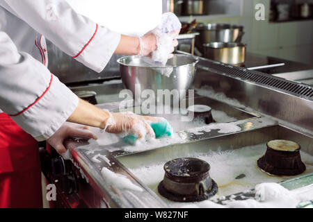 Jour sanitaire dans le restaurant. Lavez vos répétitions de travail. Laver cuisine four, cuisinière et hotte dans le restaurant. Banque D'Images