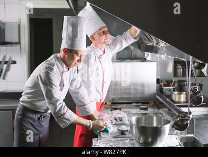 Jour sanitaire dans le restaurant. Lavez vos répétitions de travail. Laver cuisine four, cuisinière et hotte dans le restaurant. Banque D'Images