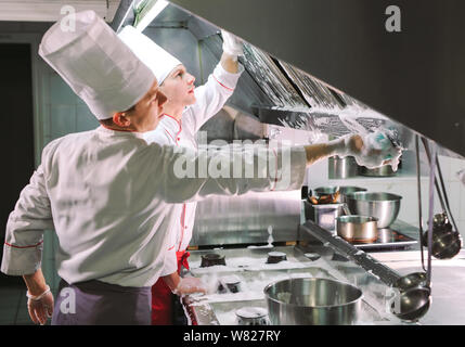 Jour sanitaire dans le restaurant. Lavez vos répétitions de travail. Laver cuisine four, cuisinière et hotte dans le restaurant. Banque D'Images