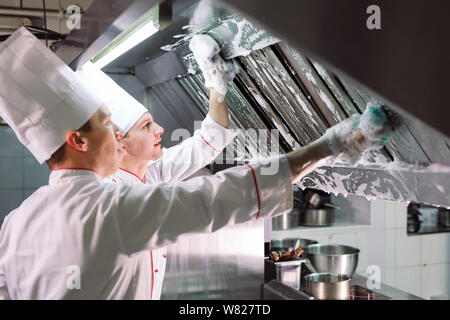 Jour sanitaire dans le restaurant. Lavez vos répétitions de travail. Laver cuisine four, cuisinière et hotte dans le restaurant. Banque D'Images