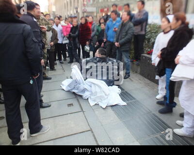 27-year-old man 220kg Xiao Huang, qui n'a pas réussi à se lever après qu'il glisse et tombe sur un trottoir, se trouve sur une route en dehors de l'hôpital de Wuhan, 100 Banque D'Images