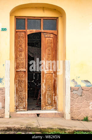 Trinidaad, Cuba 26 Nov 2017 - demi ouvert sur une porte rouge mur jaune Banque D'Images