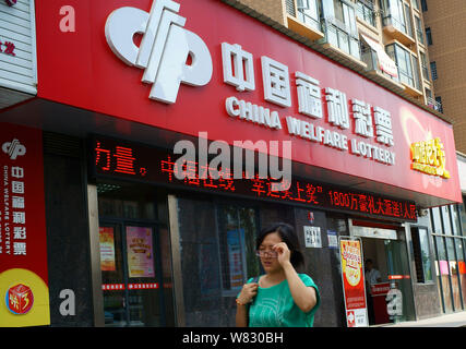 --FILE--un piéton passe devant un bureau de vente de la loterie du bien-être de la Chine dans la ville de Yichang, Chine centrale®s la province du Hubei, 12 septembre 2016. La Chine" Banque D'Images