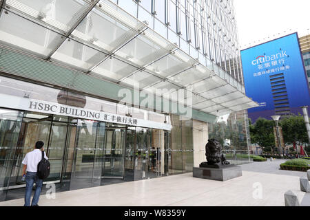 --FILE--un piéton passe devant le bâtiment de la HSBC dans le quartier financier de Lujiazui à Pudong, Shanghai, Chine, 22 août 2014. Les plus attrayants Banque D'Images