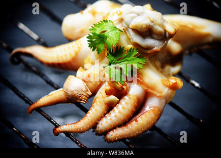 Apéritif grillé calmar les aliments chauds et épicés de fruits de mer sauce chili cuit dans le restaurant / tentacules de pieuvre d'herbes et d'épices sur le gril Banque D'Images